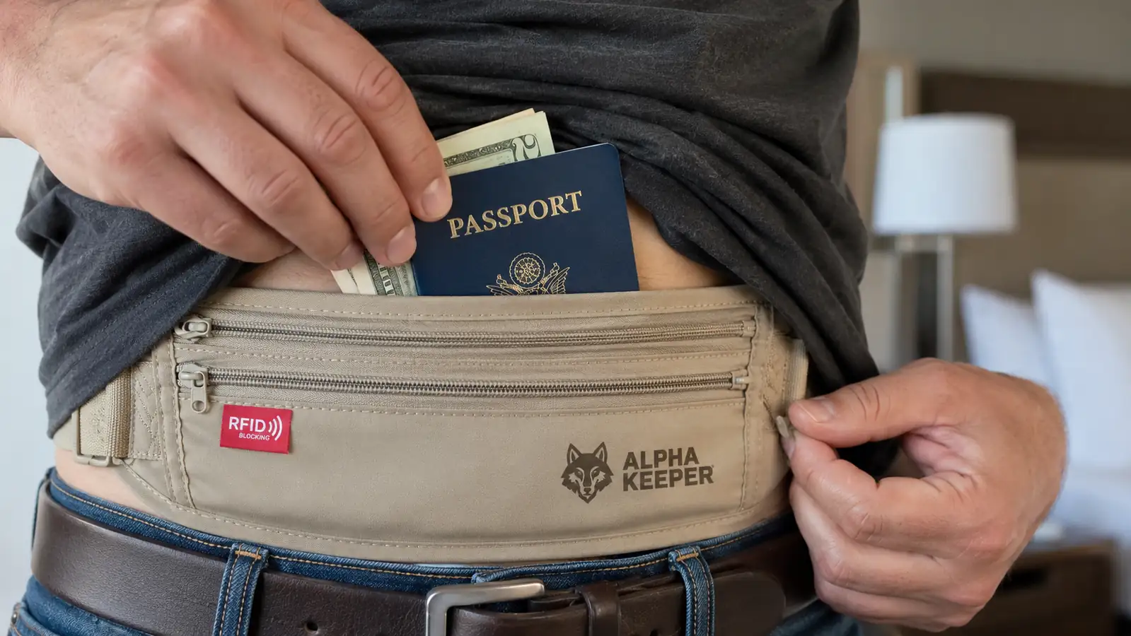 Hand tucking a passport and folded cash into a hidden waist money belt